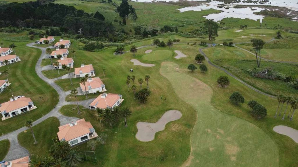 Aerial view of villa homes near the coast showing exterior roof and wall colour